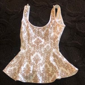 A white and gold form fitting tank